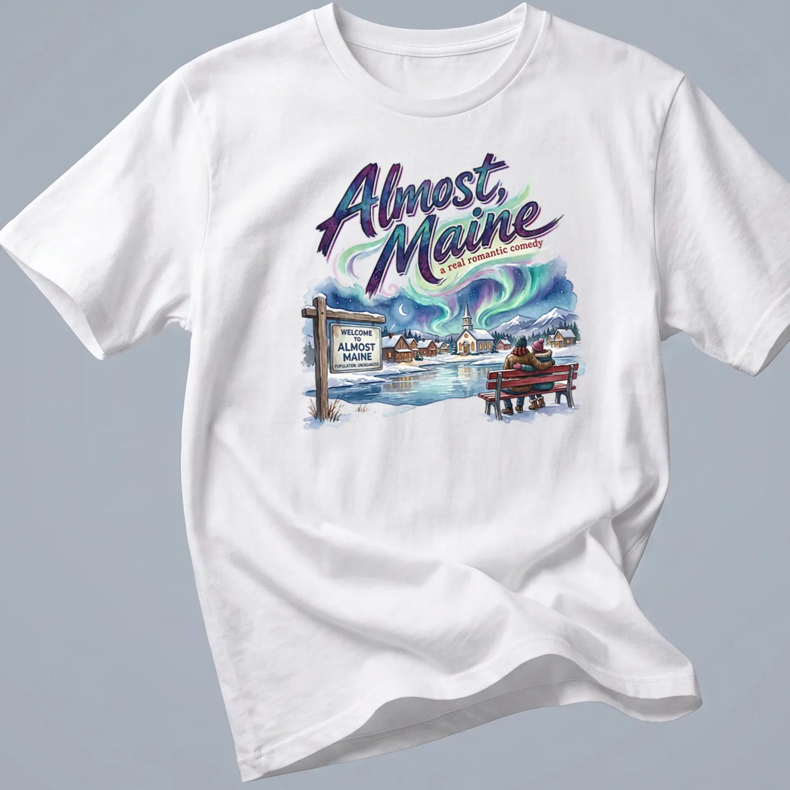 Colorful illustration of a couple sitting on a snowy bench with the title of the play above them. — printed on a unisex t-shirt