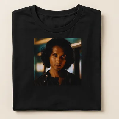 Dramatic portrait of Armand in dark hues with blue and gold accents — printed on a women's shirt