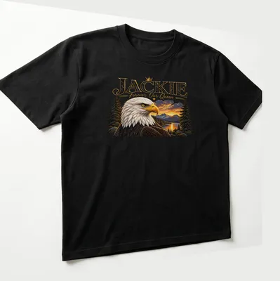 Realistic print of a Bald Eagle with the text 'JACKIE Forever Our Queen' below — printed on a unisex t-shirt (angled view)