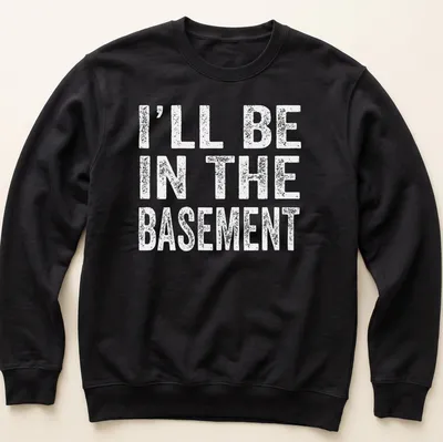 Casual black and white t-shirt with the phrase 'I'll Be In The Basement' printed on it — printed on a unisex sweatshirt