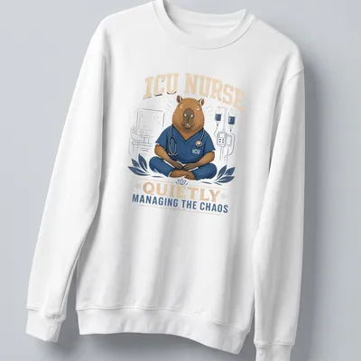 Cartoon capybara nurse in scrubs managing chaos with medical tools — printed on a unisex sweatshirt