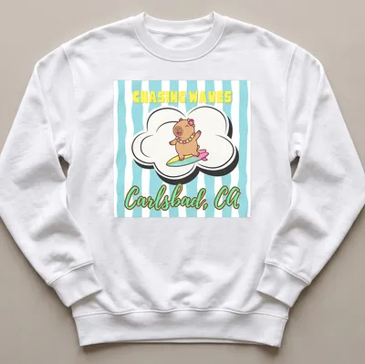 Cute cartoon capybara surfing with cheerful colors and text — printed on a unisex sweatshirt