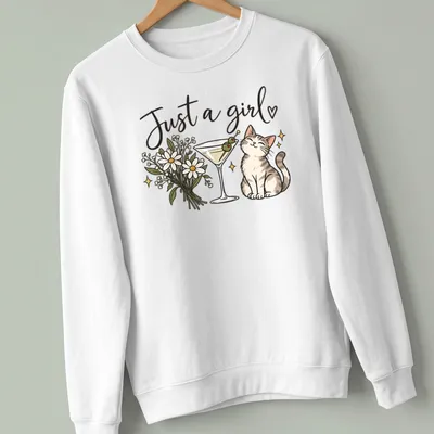 Kawaii line-art of a cute cat with a martini and text below it reading 'Just a girl' — printed on a unisex sweatshirt