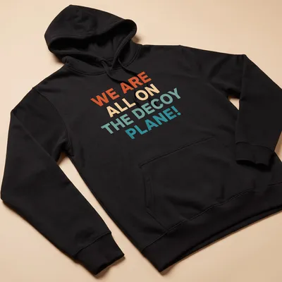 Colorful decoy plane graphic with bold text proclaiming we are all on the decoy plane — printed on a unisex hoodie