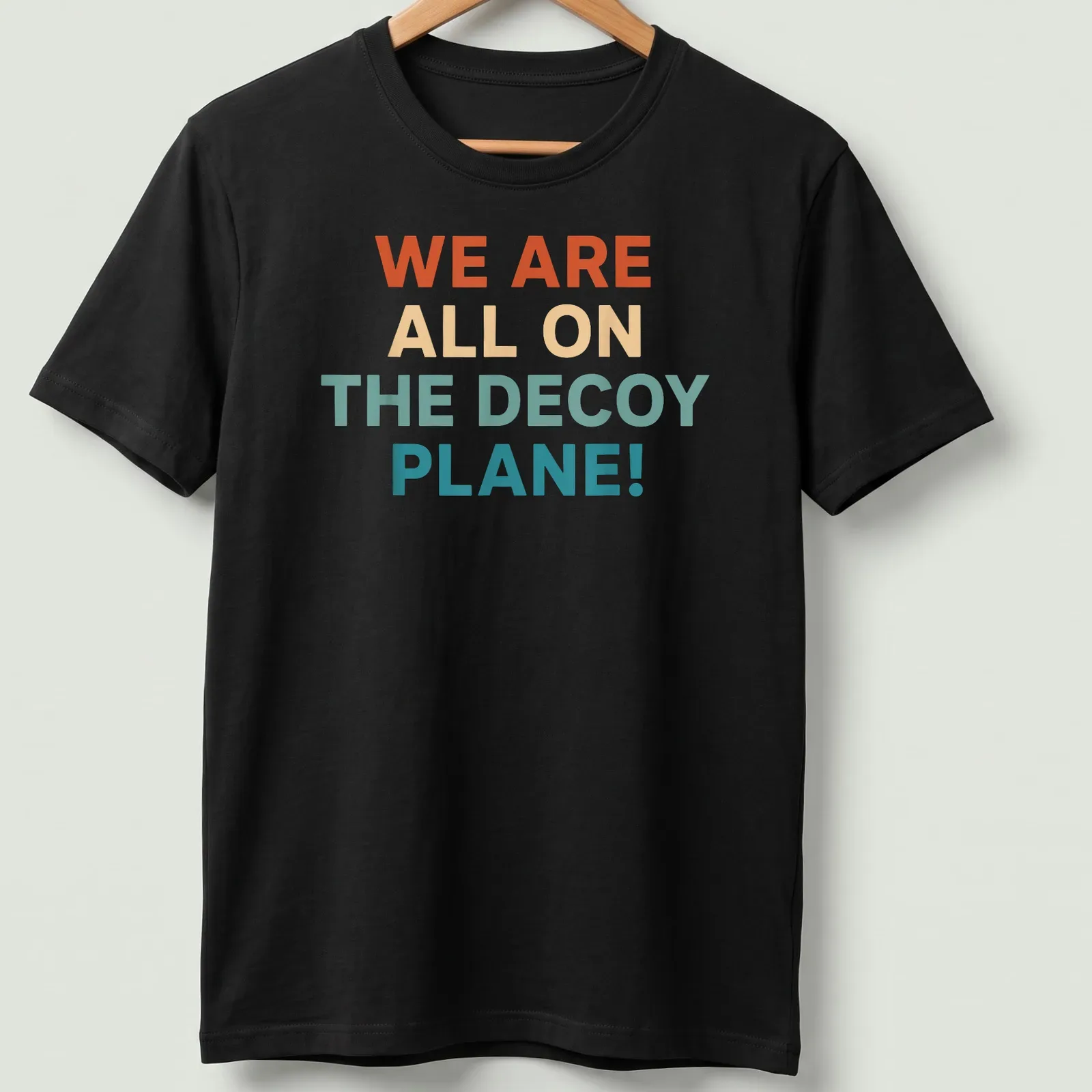 Colorful decoy plane graphic with bold text proclaiming we are all on the decoy plane — printed on a unisex t-shirt