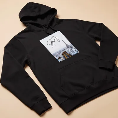 Minimalist print features the Eiffel Tower with 'HELLO Spring' text in light blue and gold — printed on a unisex hoodie
