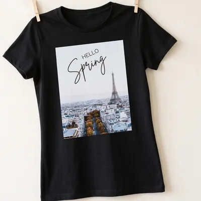 Minimalist print features the Eiffel Tower with 'HELLO Spring' text in light blue and gold — printed on a women's shirt