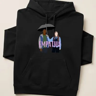 Flat design of two figures sharing an umbrella with the word 'EMPATHIE' above them — printed on a unisex hoodie