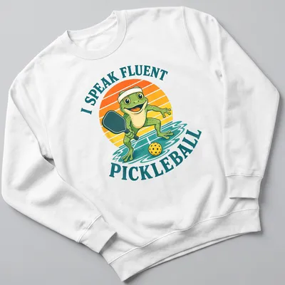 Vintage cartoon frog t-shirt featuring the phrase 'I Speak Fluent Pickleball' in colorful lettering — printed on a unisex sweatshirt