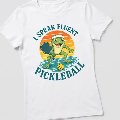 Vintage cartoon frog t-shirt featuring the phrase 'I Speak Fluent Pickleball' in colorful lettering — printed on a women's shirt