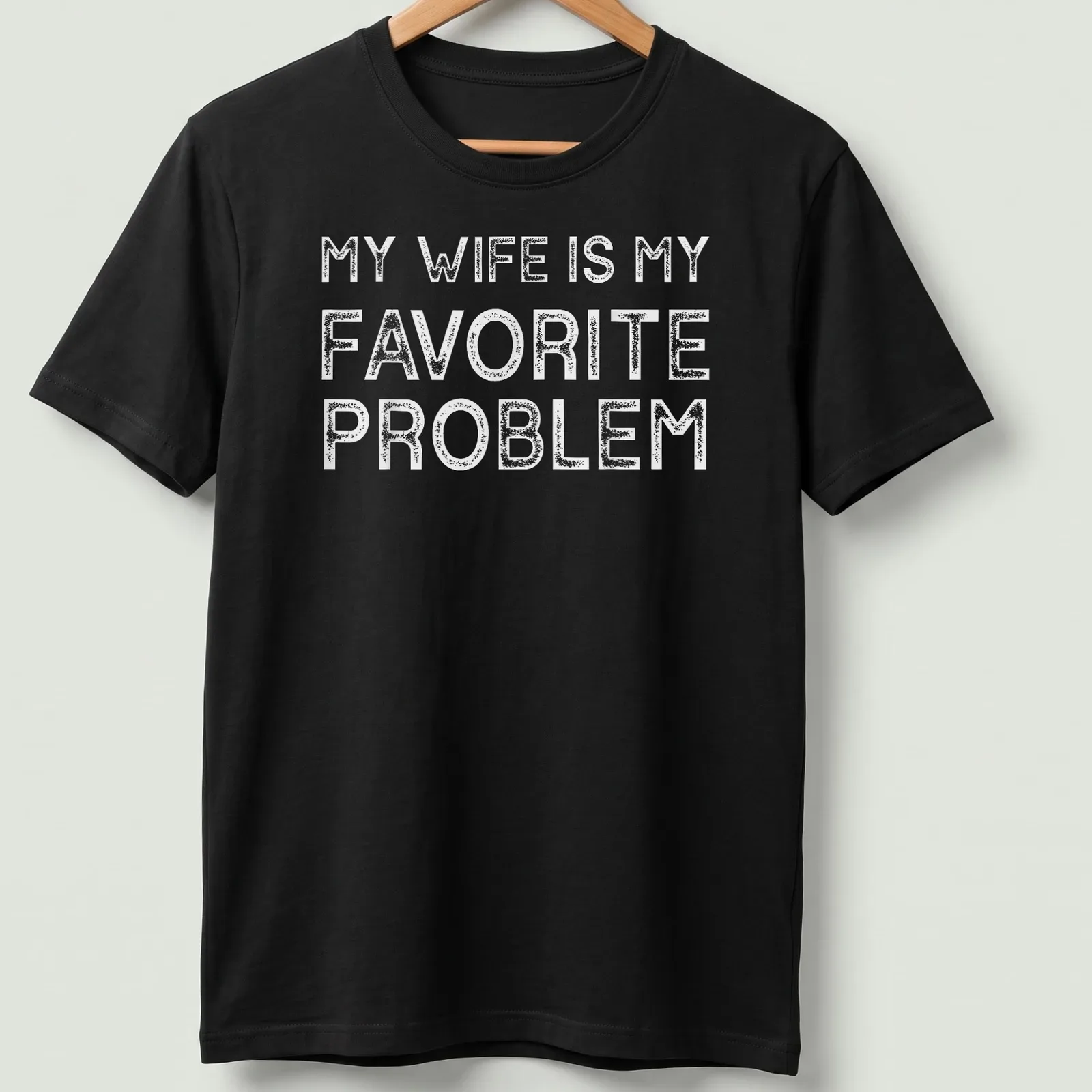 Bold typography T-shirt with the text 'MY WIFE IS MY FAVORITE PROBLEM' in white — printed on a unisex t-shirt