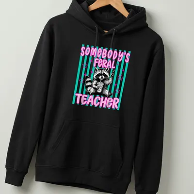 Cartoon raccoon with text 'Somebody's Feral Teacher' in pink, black, teal, and white — printed on a unisex hoodie