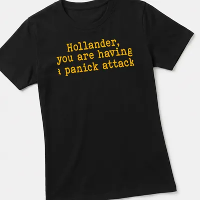 Bold yellow text on a t-shirt reads 'Hollander, you are having a panick attack' in playful typography — printed on a women's shirt