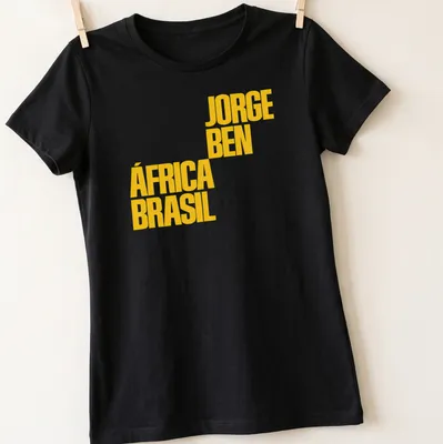 Bold yellow typography featuring Jorge Ben África Brasil text on a — printed on a women's shirt
