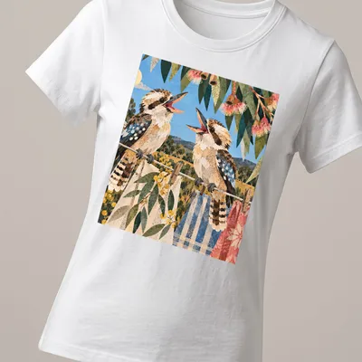 Vintage illustrated t-shirt featuring laughing kookaburras in soft colors — printed on a women's shirt