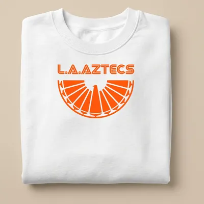 Bold geometric L.A. Aztecs soccer tee featuring an eagle emblem in orange. — printed on a unisex sweatshirt