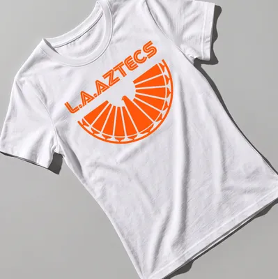 Bold geometric L.A. Aztecs soccer tee featuring an eagle emblem in orange. — printed on a women's shirt