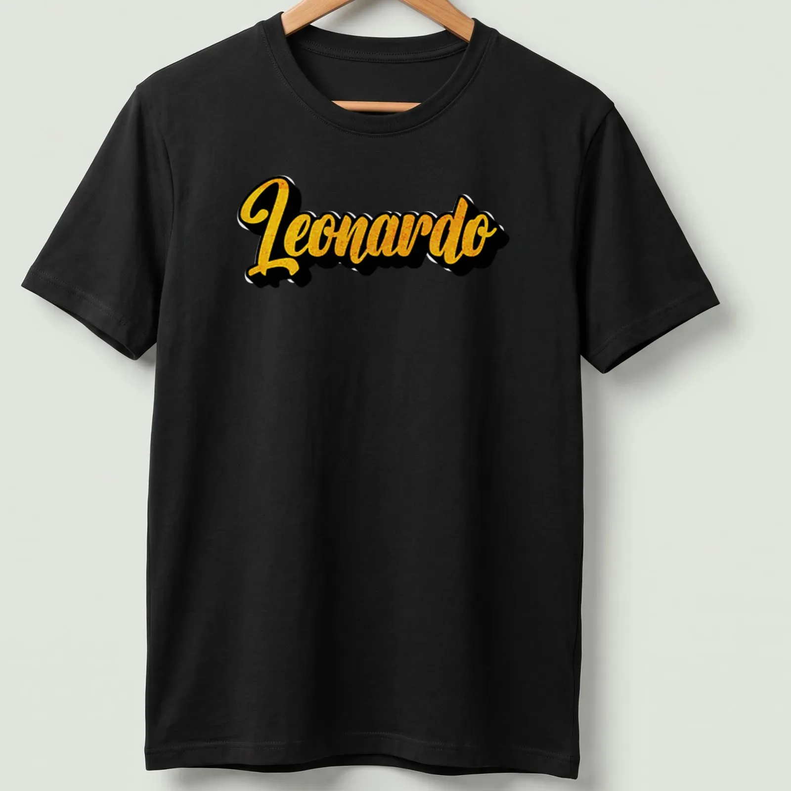 Stylized yellow script of the name Leonardo on a black — printed on a unisex t-shirt