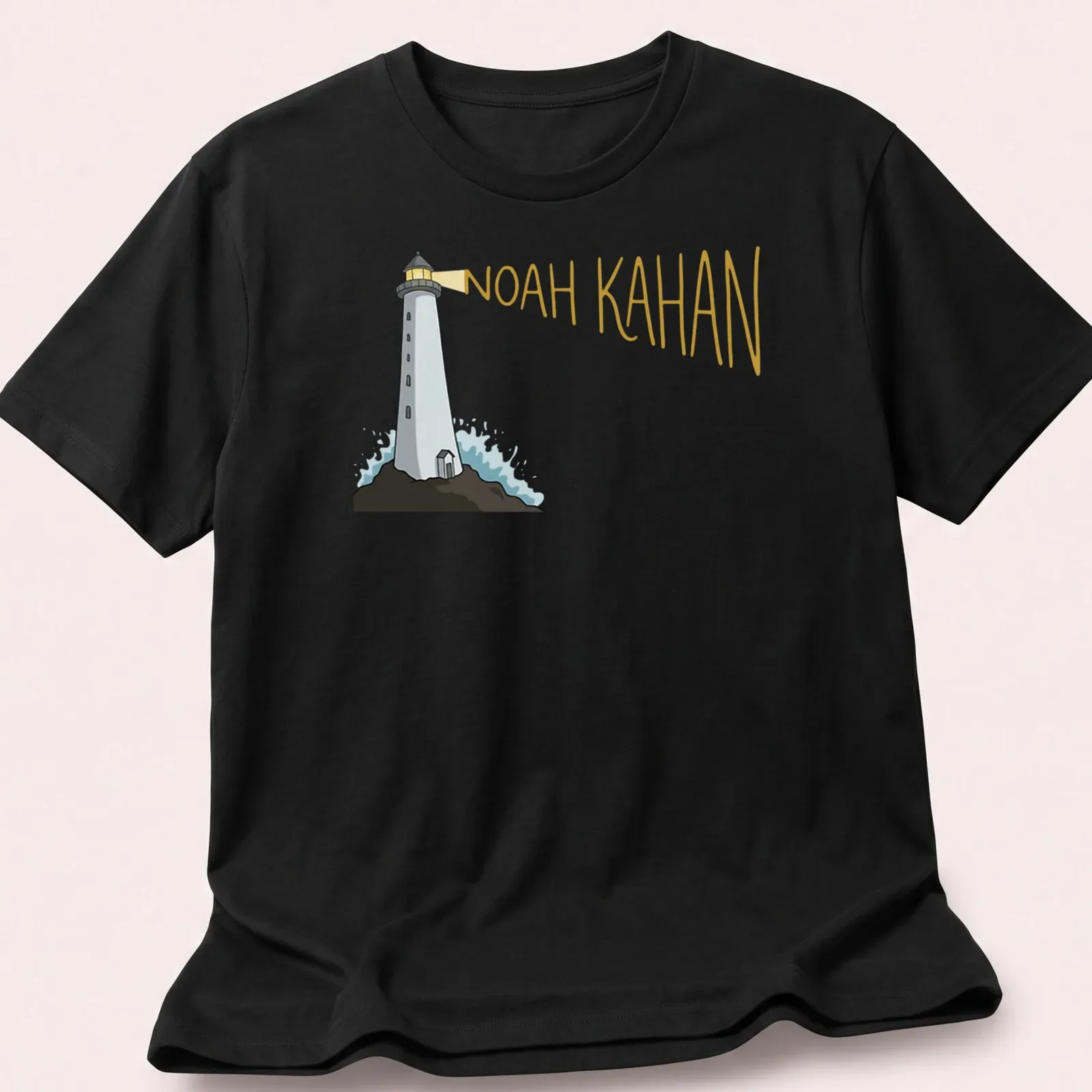 Cartoon lighthouse design with 'Noah Kahan' text in white, blue, and yellow — printed on a unisex t-shirt