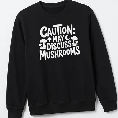 Playful typography shirt with 'Caution May Discuss Mushrooms' and whimsical mushroom illustrations — printed on a unisex sweatshirt