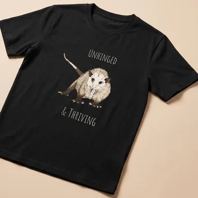 Sketch illustration of an opossum with the text 'UNHINGED & THRIVING' in earthy colors