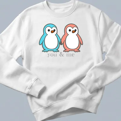 Kawaii design of two penguins holding flippers with 'you & me' text — printed on a unisex sweatshirt