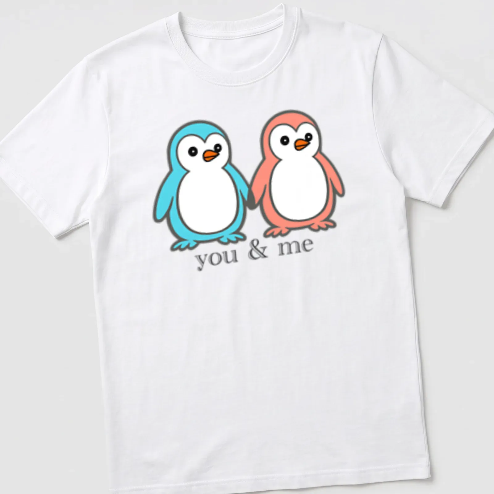 Kawaii design of two penguins holding flippers with 'you & me' text — printed on a unisex t-shirt