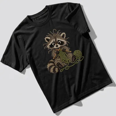 Whimsical raccoon knitting in faux cross stitch style, featuring brown and green colors — printed on a unisex t-shirt