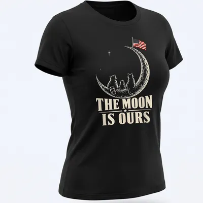 Whimsical design of raccoons on the moon with an American flag and text. — printed on a women's shirt