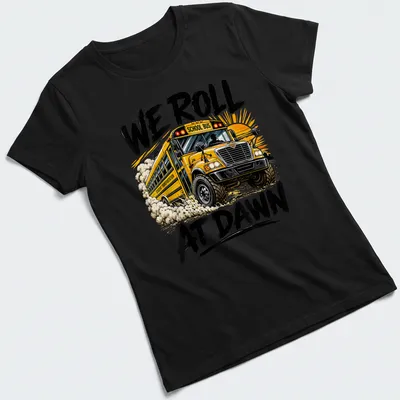 Bold graphic t-shirt featuring a school bus and the phrase We Roll At Dawn — printed on a women's shirt