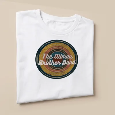 Vintage Allman Brother Band t-shirt featuring colorful text in a retro style — printed on a unisex t-shirt (angled view)