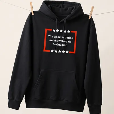 Red and white t-shirt featuring bold text of a political commentary — printed on a unisex hoodie