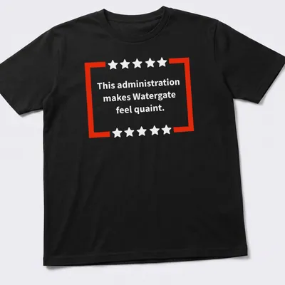 Red and white t-shirt featuring bold text of a political commentary
