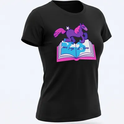 Colorful cartoon unicorn with text 'one page at a time' in purple, pink, and blue — printed on a women's shirt