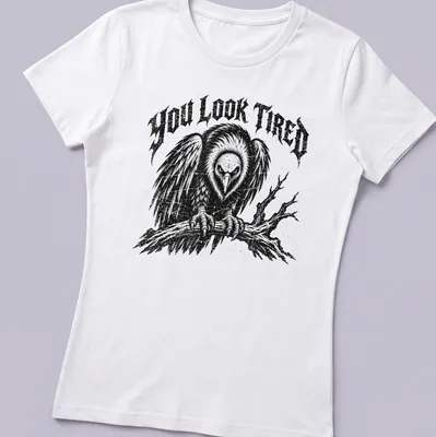 Vintage distressed t-shirt featuring a cartoon vulture and the phrase 'YOU LOOK TIRED' — printed on a women's shirt