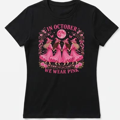 Whimsical illustration of witch sisters with text 'In October We Wear Pink' in pink tones. — printed on a women's shirt